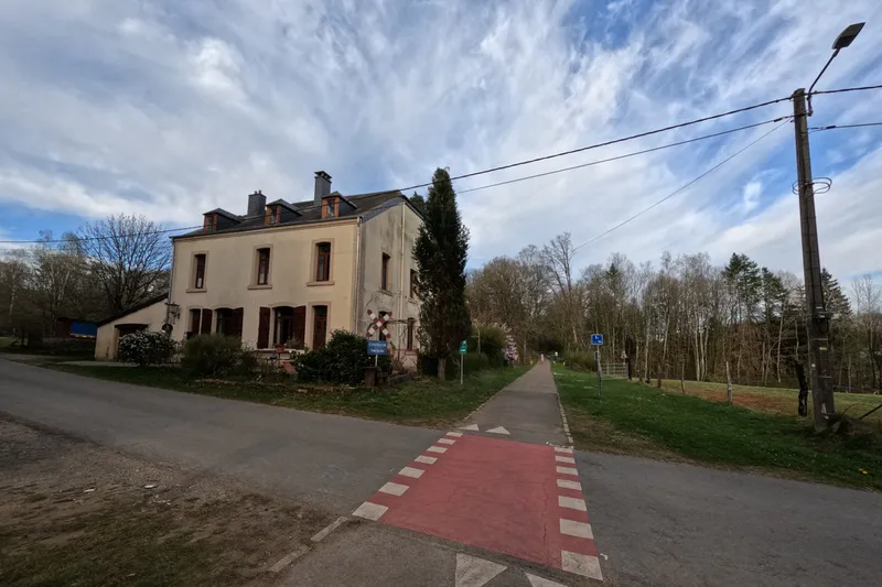 A red cycle crossing on a country road beside a house