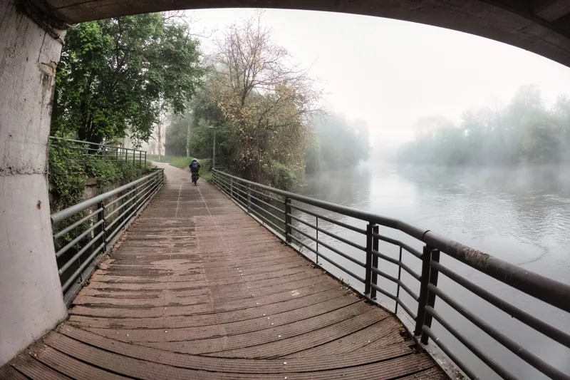 A wooden walkway along a misty river