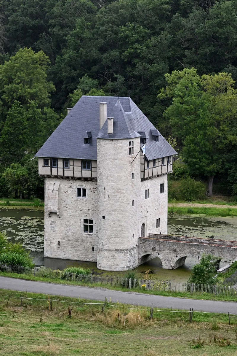 The Crupet castle keep surrounded by water and trees