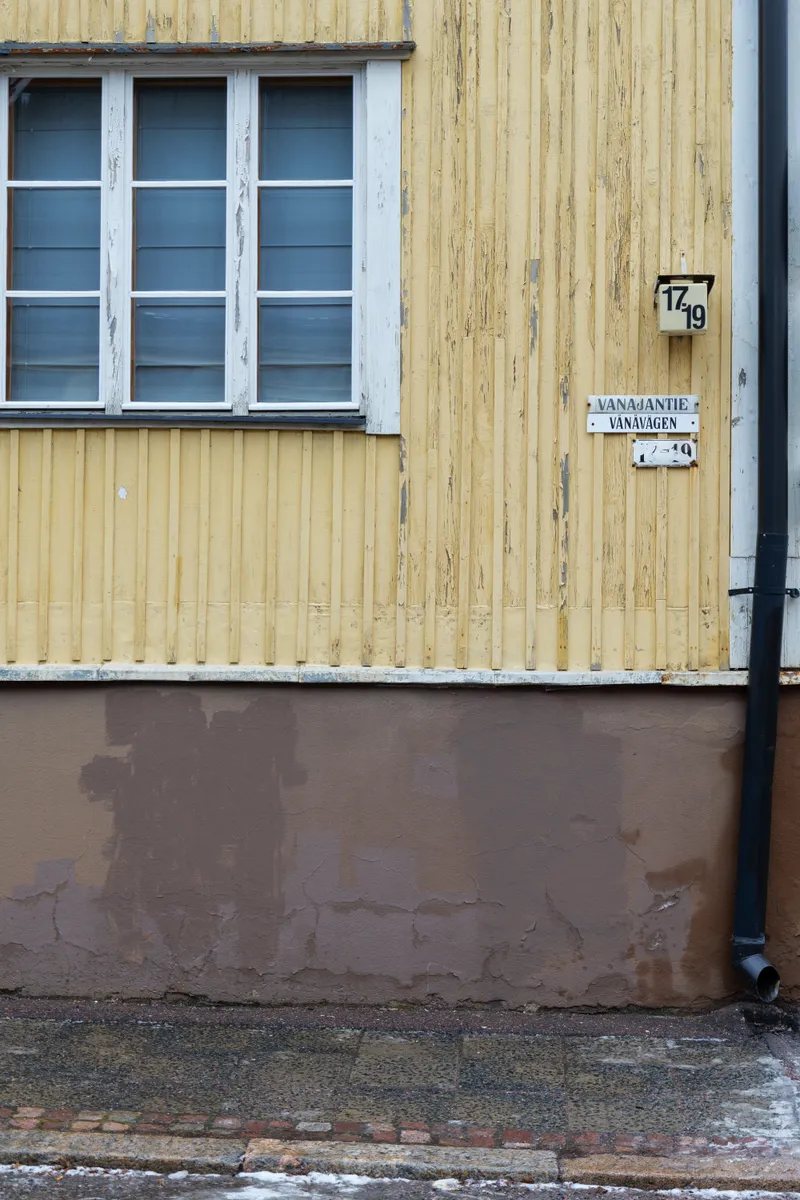 Close-up of a yellow wooden building with a window in Vallila, Helsinki