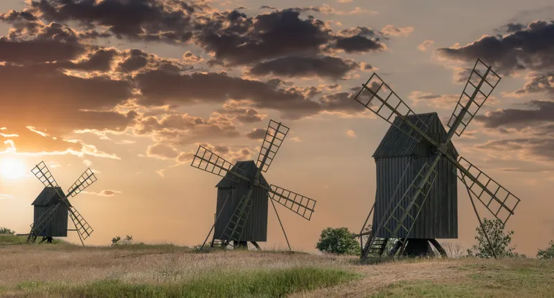 Three wooden windmills on Öland at sunset