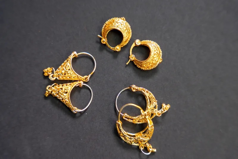 Gold-plated earrings on a dark grey background