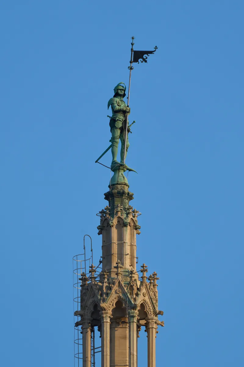 The Rathausmann statue on top of Vienna City Hall's tower against a blue sky