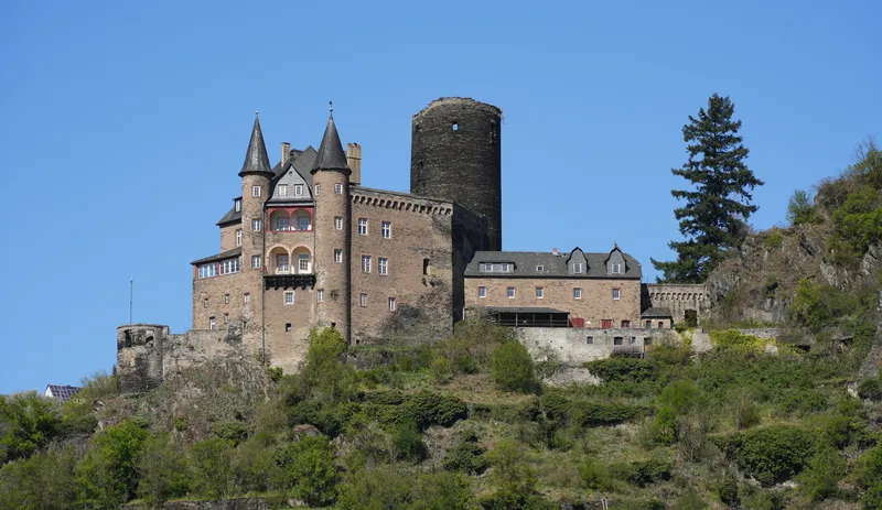 Castle Katz on a wooded hillside above the Rhine under a clear sky