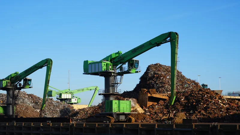 Green material-handling cranes over scrap metal piles in the Port of Rotterdam