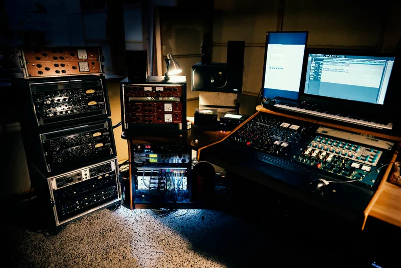 A recording studio with racks of audio equipment and monitors