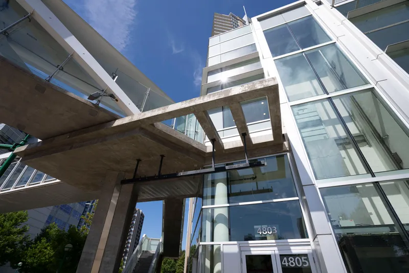 The glass front of a college building seen from below