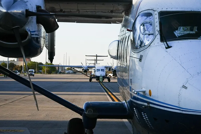 C-145A aircraft parked on the flight line, seen from under a wing