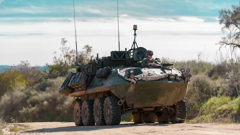 An armoured vehicle with an antenna mast on a dirt track