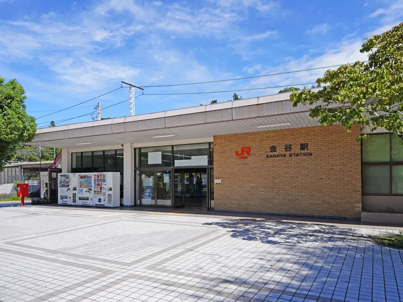 The JR Kanaya Station building under a blue sky